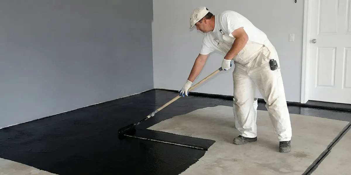 basement waterproofing professional applying waterproof coating to protect a basement floor in Colorado Springs, CO
